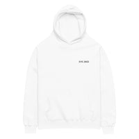 White oversized unisex hoodie with minimalist front design, featuring subtle “EST. 2025” text on the chest, clean streetwear style and relaxed fit.