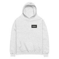 Oversized hoodie in light grey with "Minimal But Never Basic" statement typography, front view