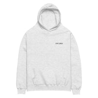 White heather oversized unisex hoodie with minimalist front design, featuring subtle “EST. 2025” text on the chest, clean streetwear style and relaxed fit.