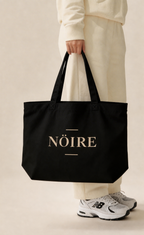 Black Nöiré logo tote bag carried by model, lifestyle product view
