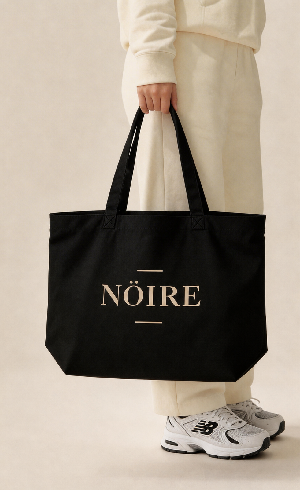 Black Nöiré logo tote bag carried by model, lifestyle product view