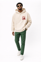 Male model in beige oversized hoodie featuring red “14” front print, contemporary streetwear fashion
