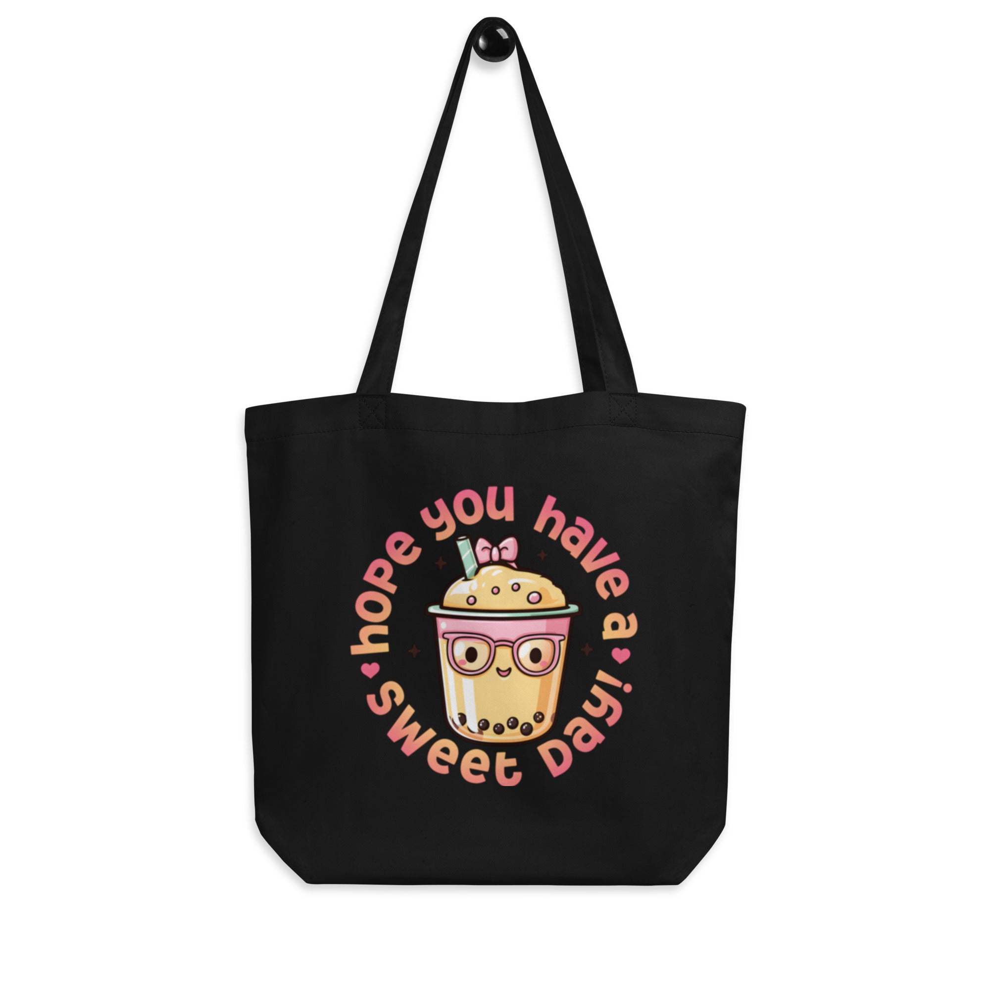 front view hanging black canvas tote bag cute bubble tea design minimal studio background streetwear fashion