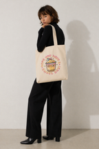 model 3/4 pose looking back holding canvas tote bag pastel kawaii drink illustration casual outfit aesthetic