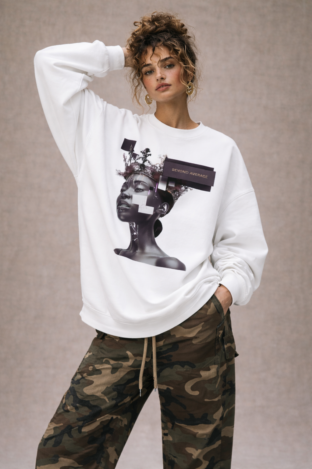 Female model wearing white oversized graphic sweatshirt with purple portrait design, minimalist streetwear fashion.