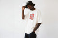 model side pose wearing oversized cream graphic t shirt with red varsity number urban streetwear outfit