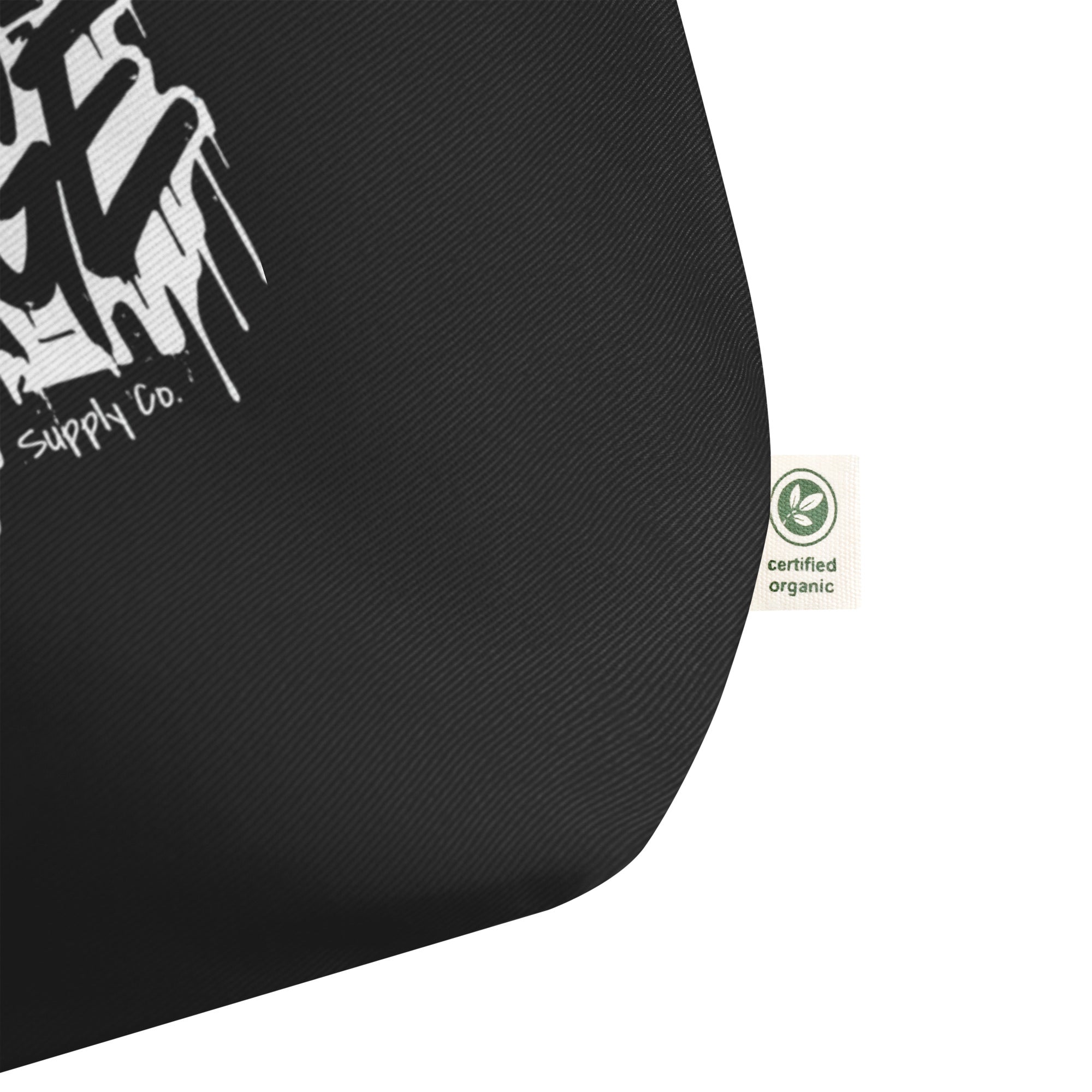 product close up view black tote bag fabric texture certified organic tag detail graphic streetwear