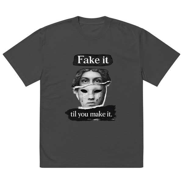 Black unisex t-shirt front view with illustrated face graphic and “Fake it til you make it” slogan, modern streetwear tee