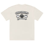 beige t-shirt back view featuring large “KEEP SMILING – STAY POSITIVE” graphic with three vintage-style smiley faces in black, urban graphic design by Noiré.