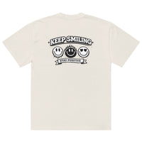 beige t-shirt back view featuring large “KEEP SMILING – STAY POSITIVE” graphic with three vintage-style smiley faces in black, urban graphic design by Noiré.