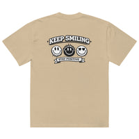 khaki t-shirt back view featuring large “KEEP SMILING – STAY POSITIVE” graphic with three vintage-style smiley faces in black, urban graphic design by Noiré.