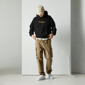 Model wearing black unisex hoodie with “No prayers needed just purpose” text design in a clean studio setting