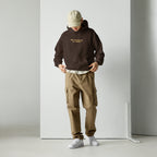 Model wearing dark chocolate unisex hoodie with “No prayers needed just purpose” text design in a clean studio setting