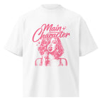 White oversized women’s t-shirt flat lay with pink “Main Character” graphic print featuring illustrated female portrait, statement streetwear tee product image.