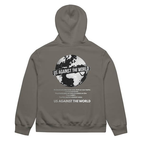 Grey unisex hoodie featuring “Us Against the World” world map graphic on the back, urban streetwear style