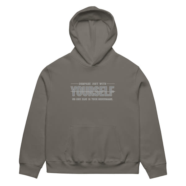 unisex streetwear hoodie front view with “compare just with yourself” motivational quote print
