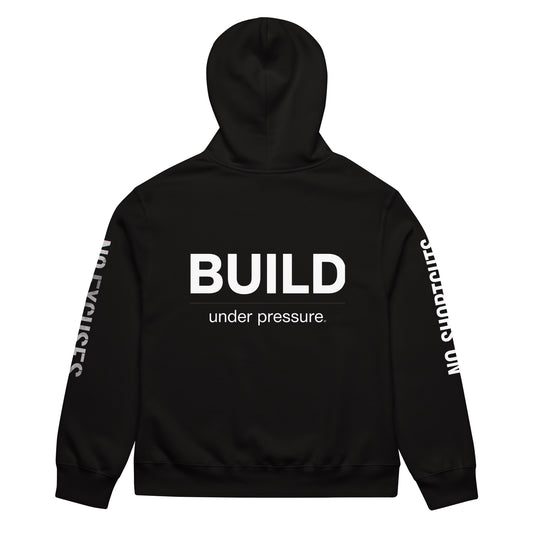 Black unisex oversized hoodie with “Build Under Pressure” statement printed on back, streetwear hoodie back view.