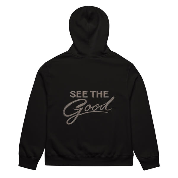 Black unisex streetwear hoodie back view with “See The Good” motivational typography print
