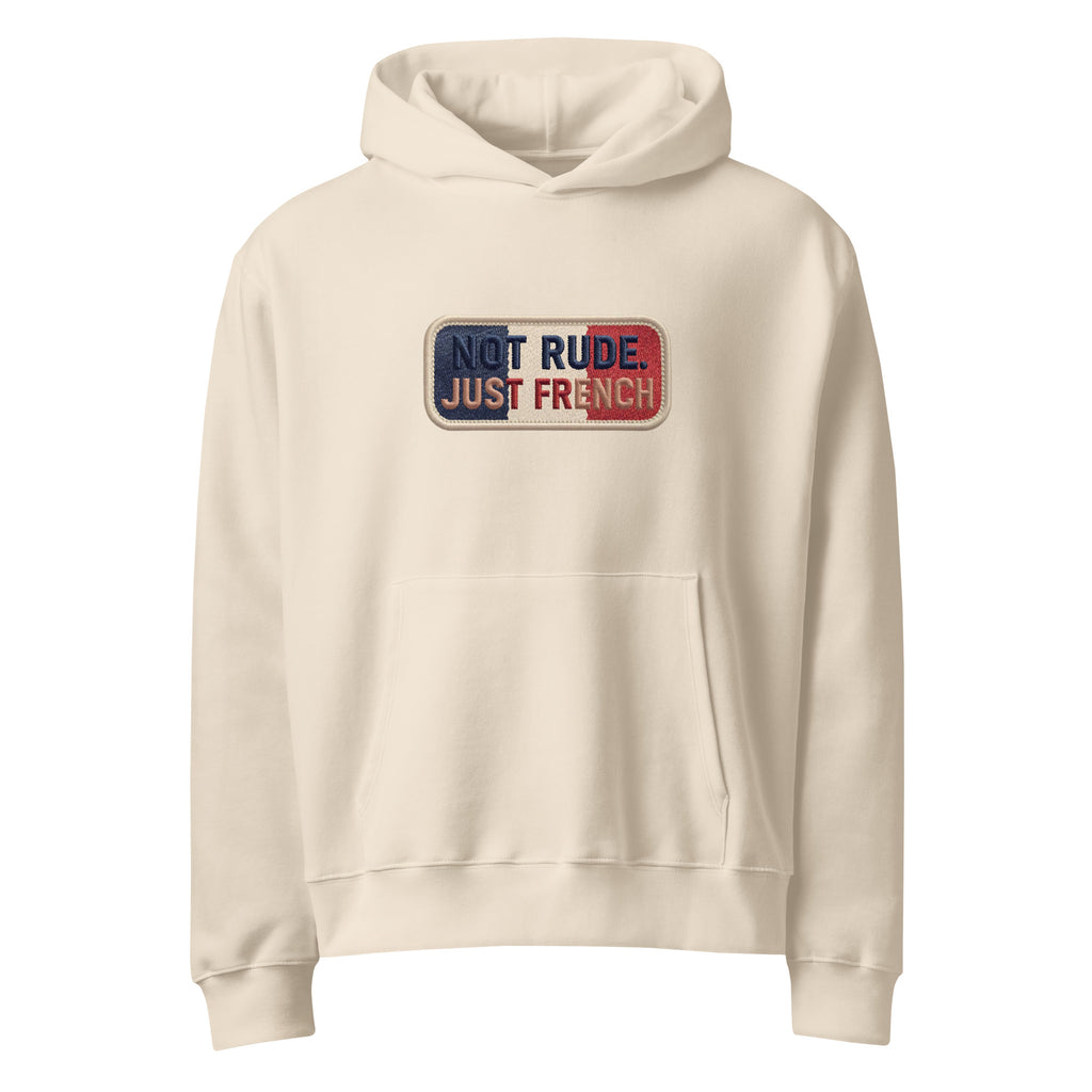 Beige oversized hoodie with “Not Rude Just French” statement patch, front view