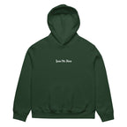Front view of forest oversized streetwear hoodie with small “Leave Me Alone” chest text print, minimalist unisex casual sweatshirt