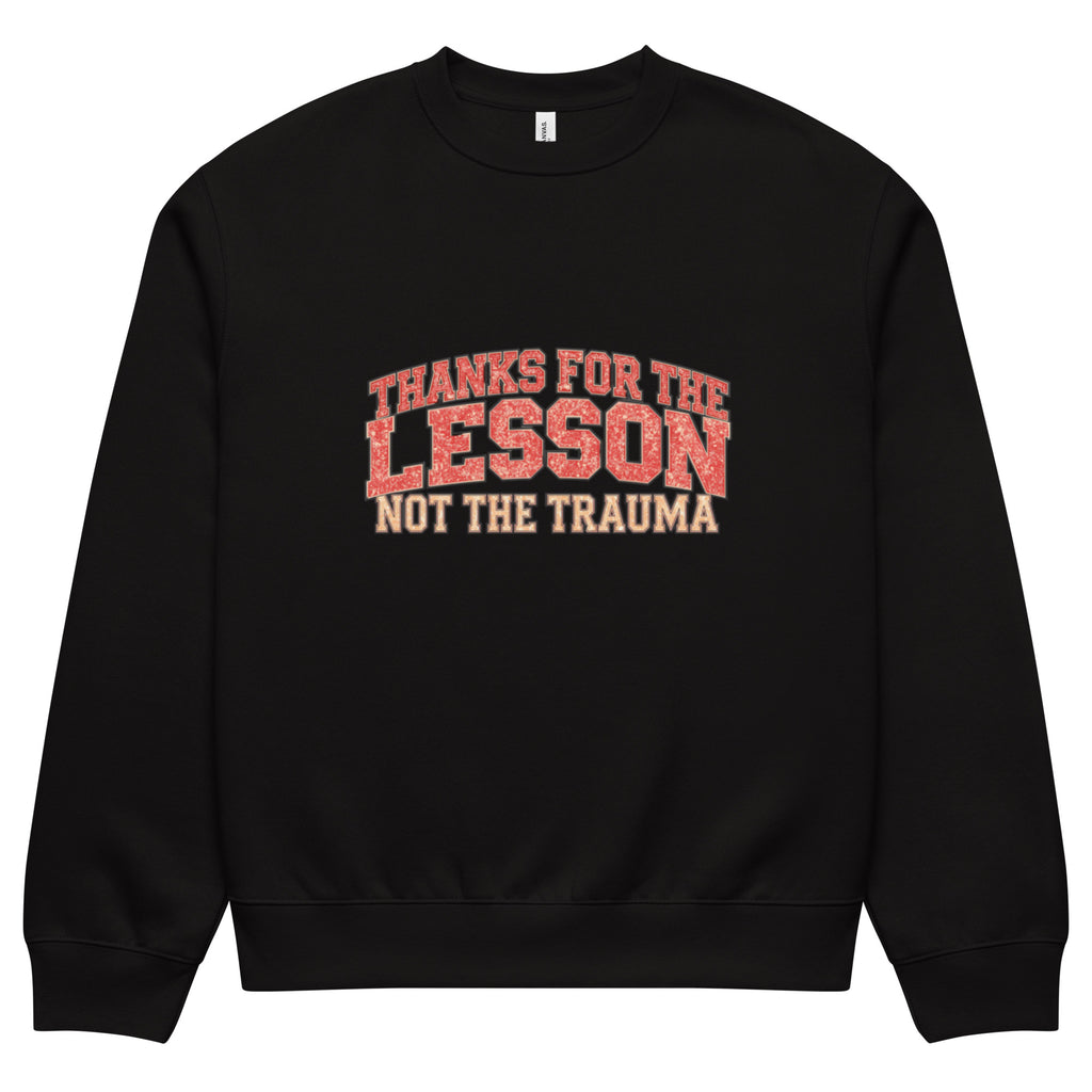 Black unisex sweatshirt front view with “Thanks for the Lesson, Not the Trauma” motivational typography print, modern streetwear pullover