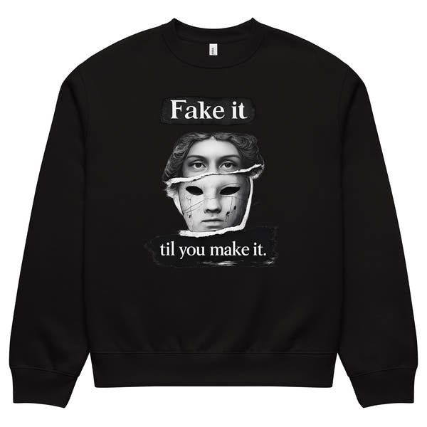 Black unisex sweatshirt front view with illustrated face graphic and “Fake it til you make it” slogan, modern streetwear crewneck