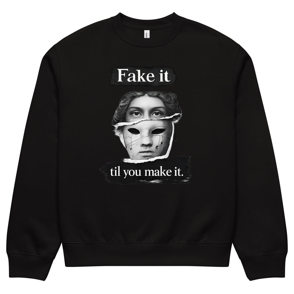Black unisex sweatshirt front view with illustrated face graphic and “Fake it til you make it” slogan, modern streetwear crewneck